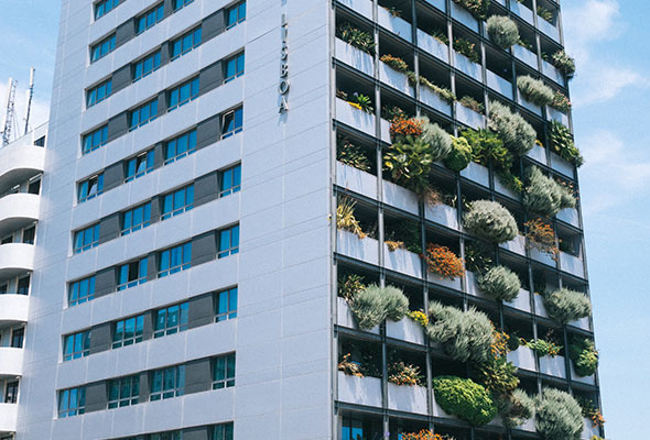 An example of compact design, tall building with flora growing out of the balcony